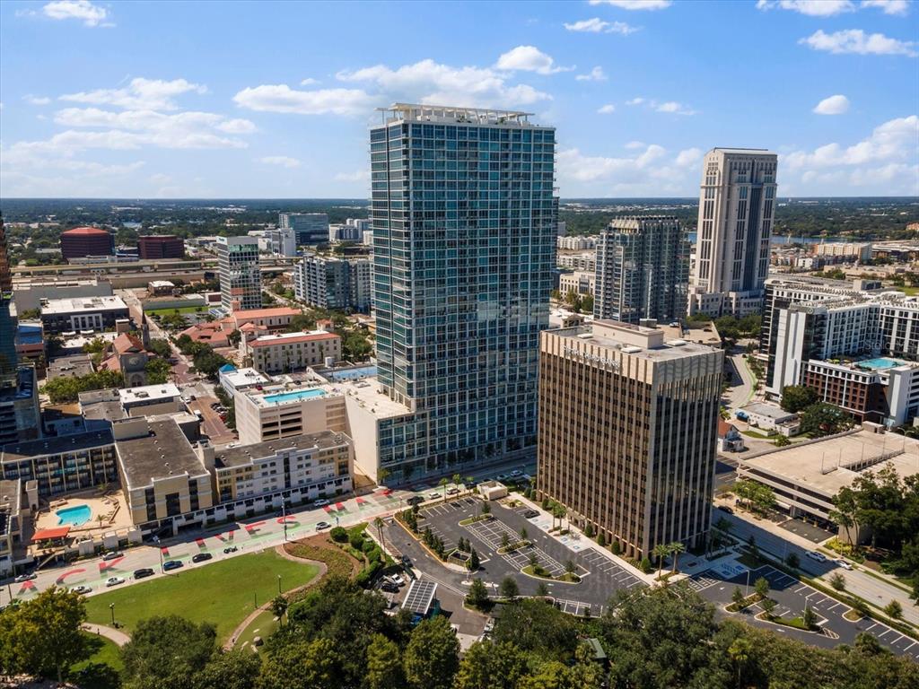 An aerial view of a city skyline featuring a tall glass skyscraper and surrounding buildings — 150 E ROBINSON STREET UNIT 3409, ORLANDO, FL