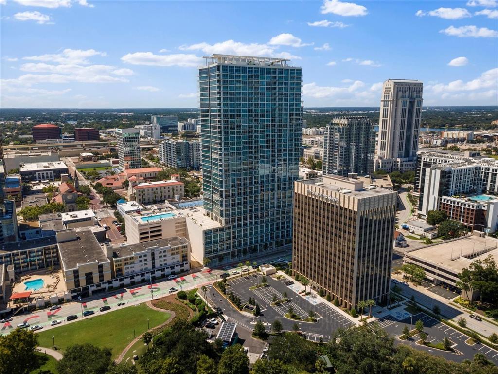 An aerial view of a city skyline featuring a tall glass skyscraper and surrounding buildings — 150 E ROBINSON STREET UNIT 3409, ORLANDO, FL