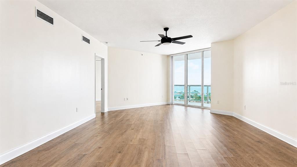 An empty room with wood-look flooring, a ceiling fan, and sliding glass doors to a balcony — 241 RIVERSIDE DRIVE UNIT 608, HOLLY HILL, FL