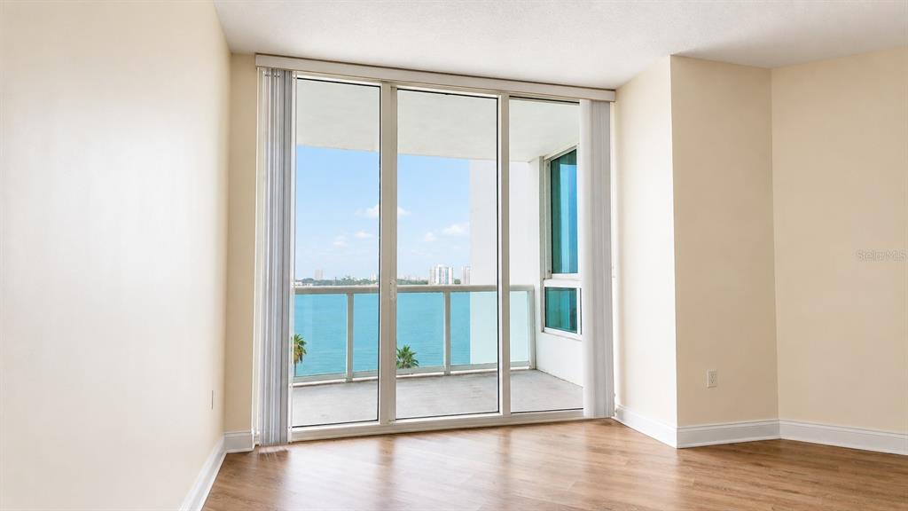 An empty room with light-colored walls, wood-look flooring, and a balcony overlooking the water — 241 RIVERSIDE DRIVE UNIT 608, HOLLY HILL, FL
