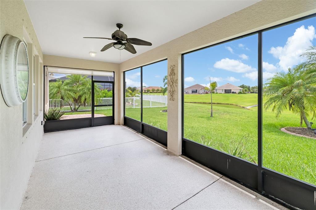 A screened-in patio features a ceiling fan, concrete flooring, and views of a grassy yard — 7726 111TH TERRACE E, PARRISH, FL