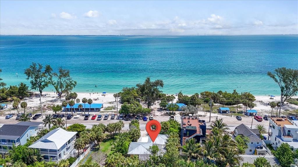 An aerial view shows a beach house with a red location pin near the ocean — 317 N BAY BOULEVARD, ANNA MARIA, FL