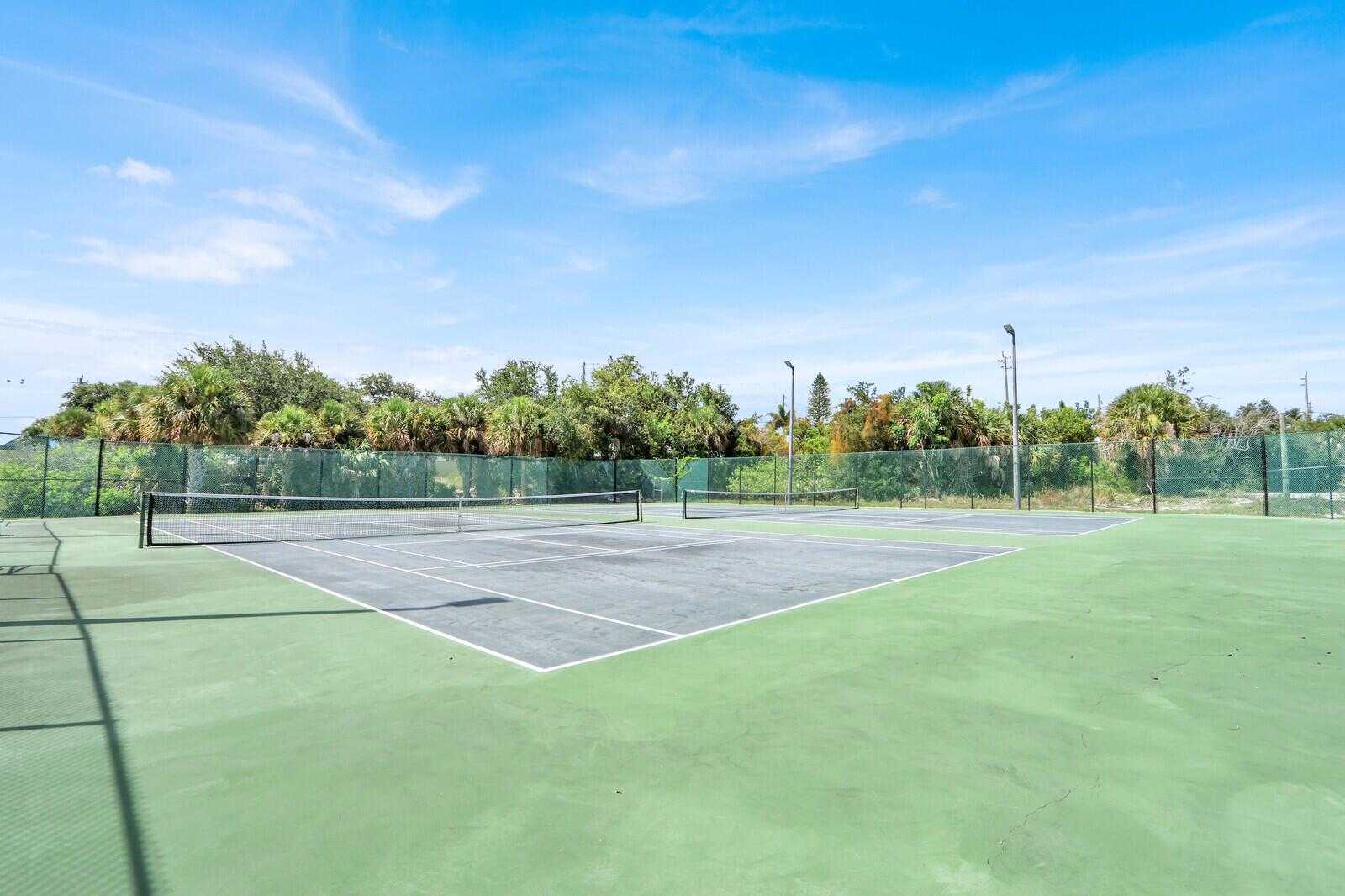 An outdoor tennis court with green and grey surfacing surrounded by a chain-link fence — 1551 NE 13th Terrace # A9, Jensen Beach FL 34957, JENSEN BEACH, FL