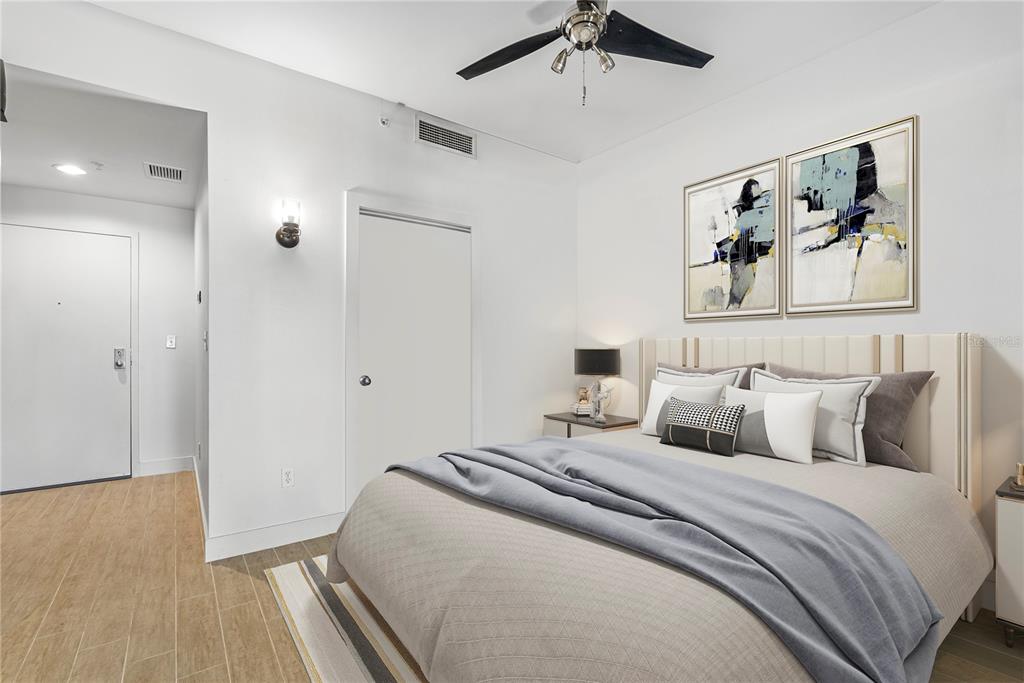 A bedroom features a bed with a light-colored headboard, a ceiling fan, and tile flooring — 1120 E KENNEDY BOULEVARD UNIT 1417, TAMPA, FL