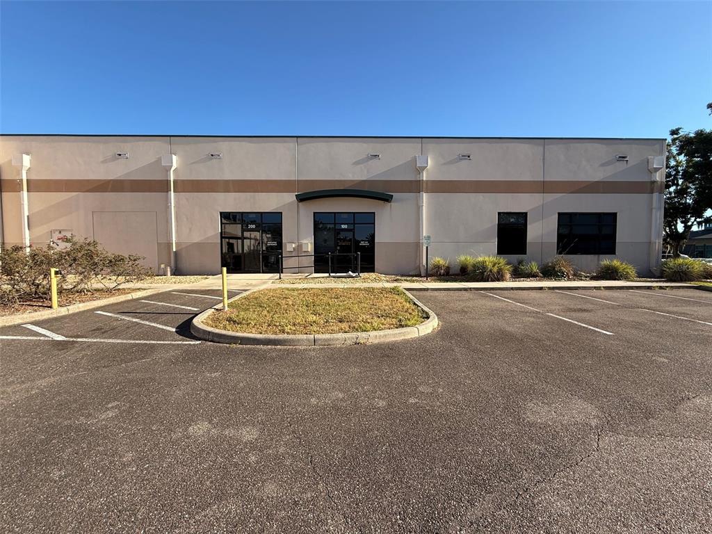 The exterior of a commercial building features a parking lot and two glass entrance doors — 13859 PROGRESS BOULEVARD 200 Cowork Units, ALACHUA, FL