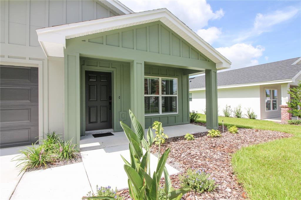 A green-trimmed front porch leads to a dark front door of a suburban house — 1242 DOROTHY STREET, LAKELAND, FL