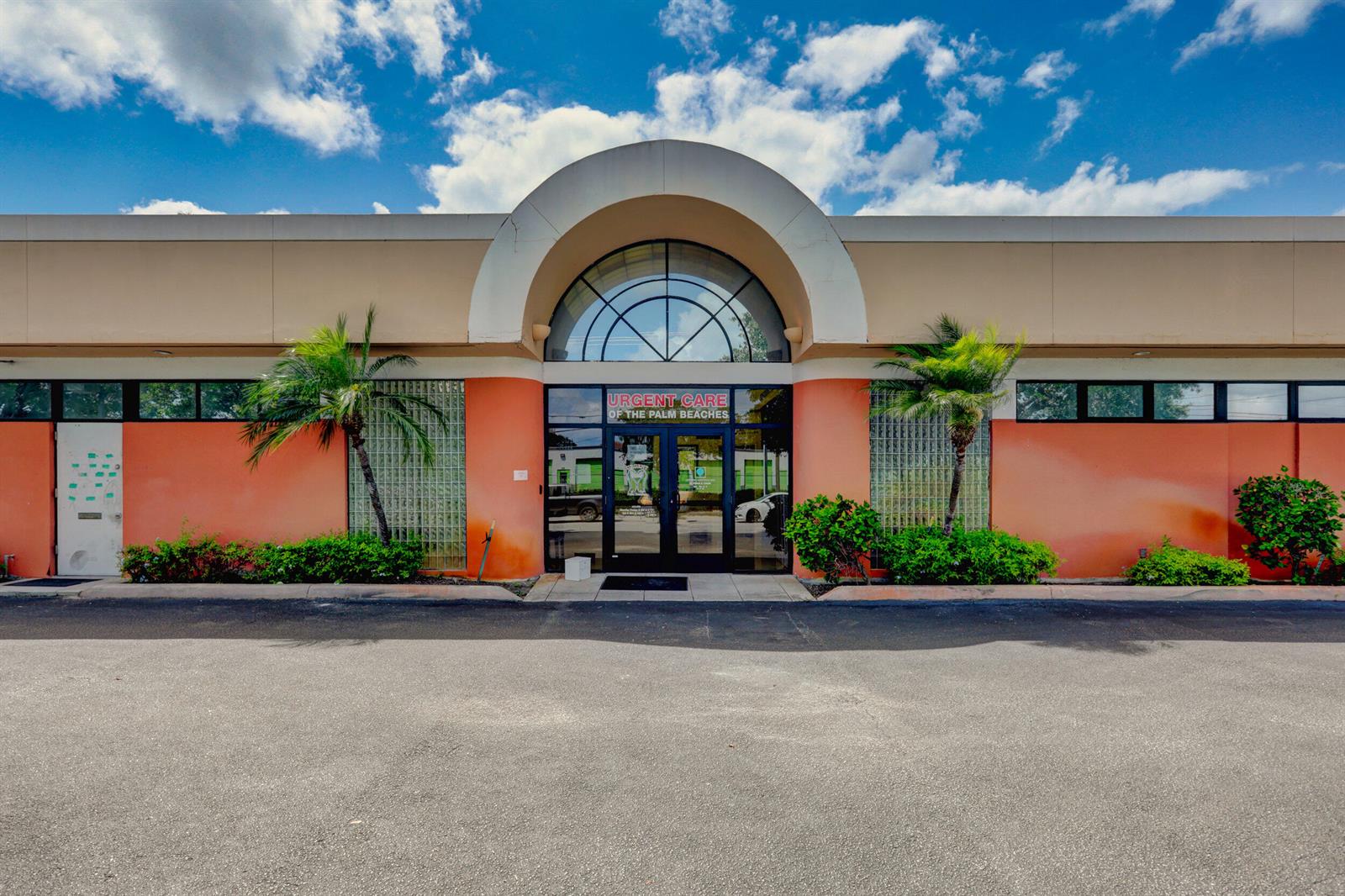 The exterior of a single-story commercial building features an arched entrance and orange stucco walls — 3537 Forest Hill Boulevard, West Palm Beach FL 33406, WEST PALM BEACH, FL