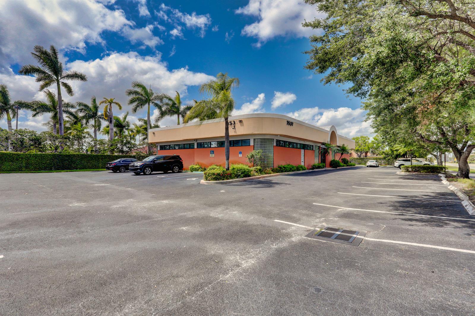A low-rise commercial building with a tan and orange exterior sits beside a parking lot — 3537 Forest Hill Boulevard, West Palm Beach FL 33406, WEST PALM BEACH, FL