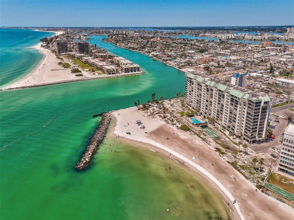 Aerial view of a coastal inlet with sandy beaches, high-rise condominiums, and turquoise water — 7100 SUNSET WAY UNIT 310, ST PETE BEACH, FL