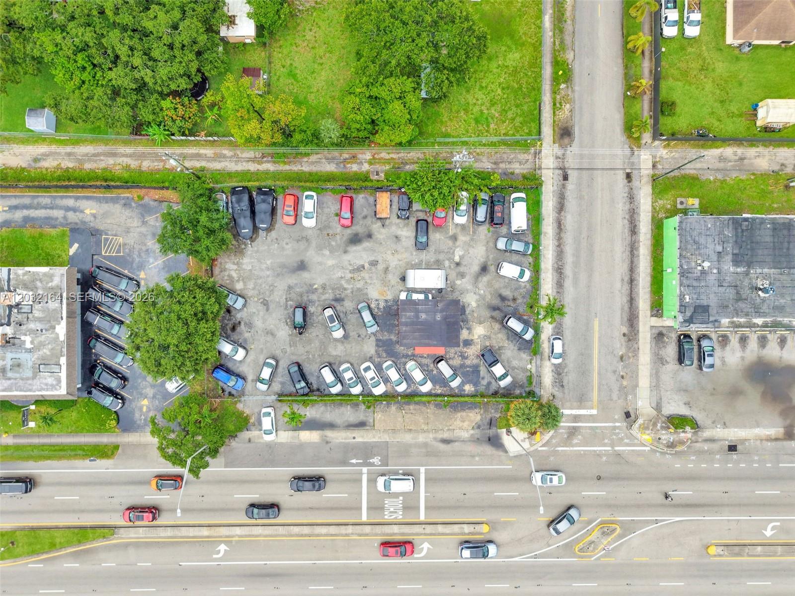 An aerial view shows a parking lot with numerous vehicles and a small building — 4601 W Hallandale Beach Blvd, Hollywood FL 33023, HOLLYWOOD, FL
