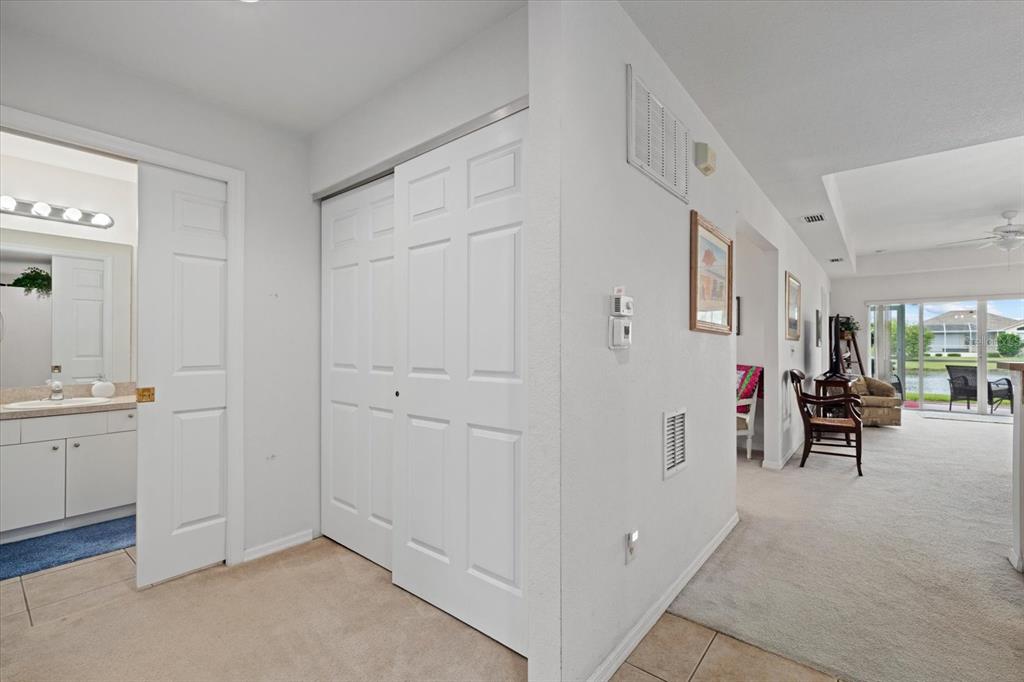 A hallway leads to a bathroom, a closet, and an open living area with sliding doors — 5738 SABAL TRACE DRIVE UNIT 1B5738, NORTH PORT, FL