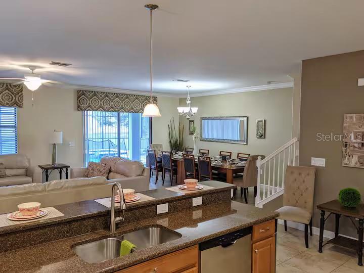 An open-concept kitchen with granite countertops overlooks a living room and a dining area — 1524 MOON VALLEY DRIVE, DAVENPORT, FL