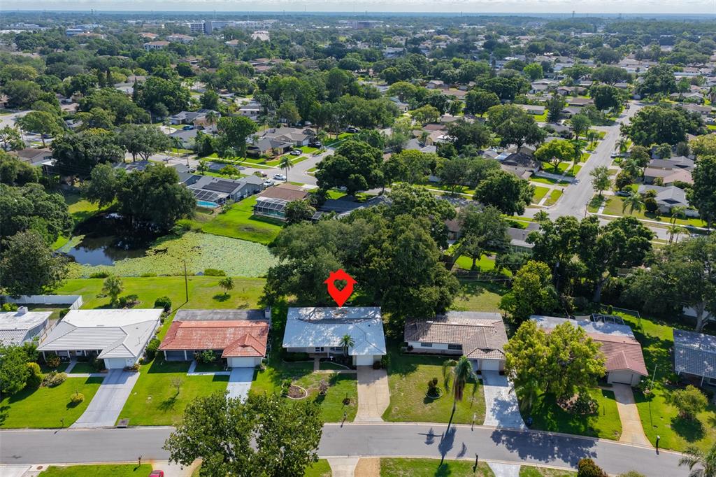 An aerial view shows a single-story house with a white roof in a suburban neighborhood — 2335 SURREY LANE, CLEARWATER, FL