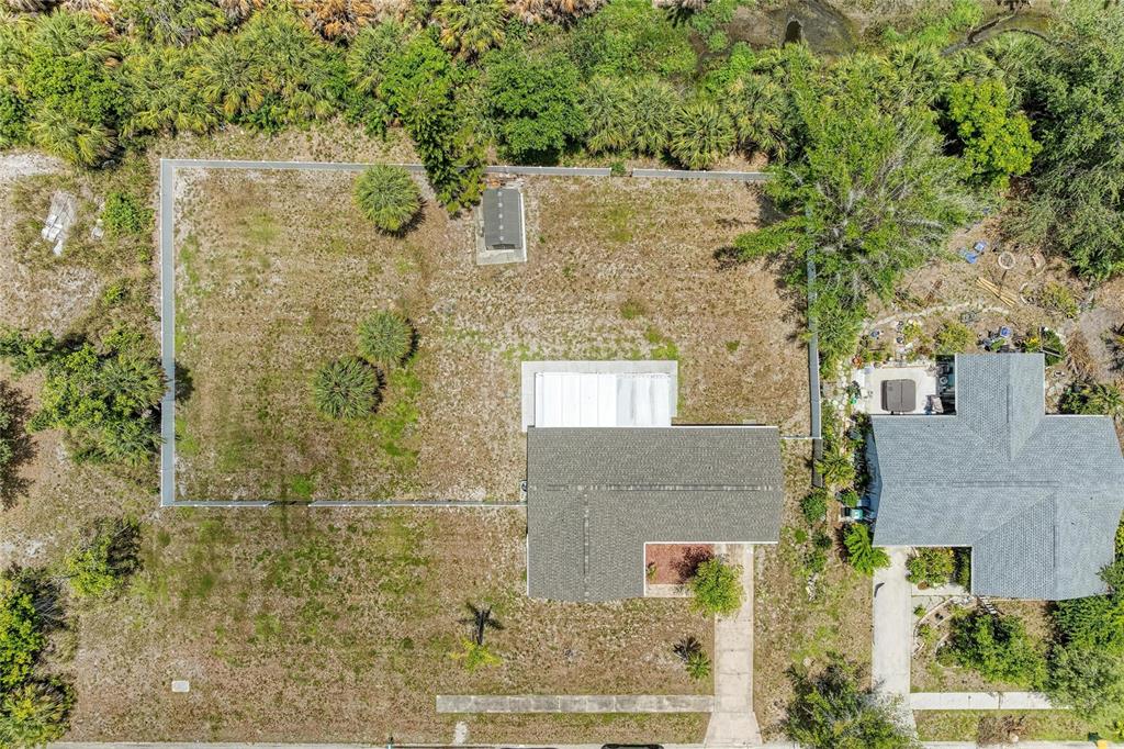 An aerial view shows a house with a fenced backyard and a small storage shed — 6310 CUTLER TERRACE, PORT CHARLOTTE, FL