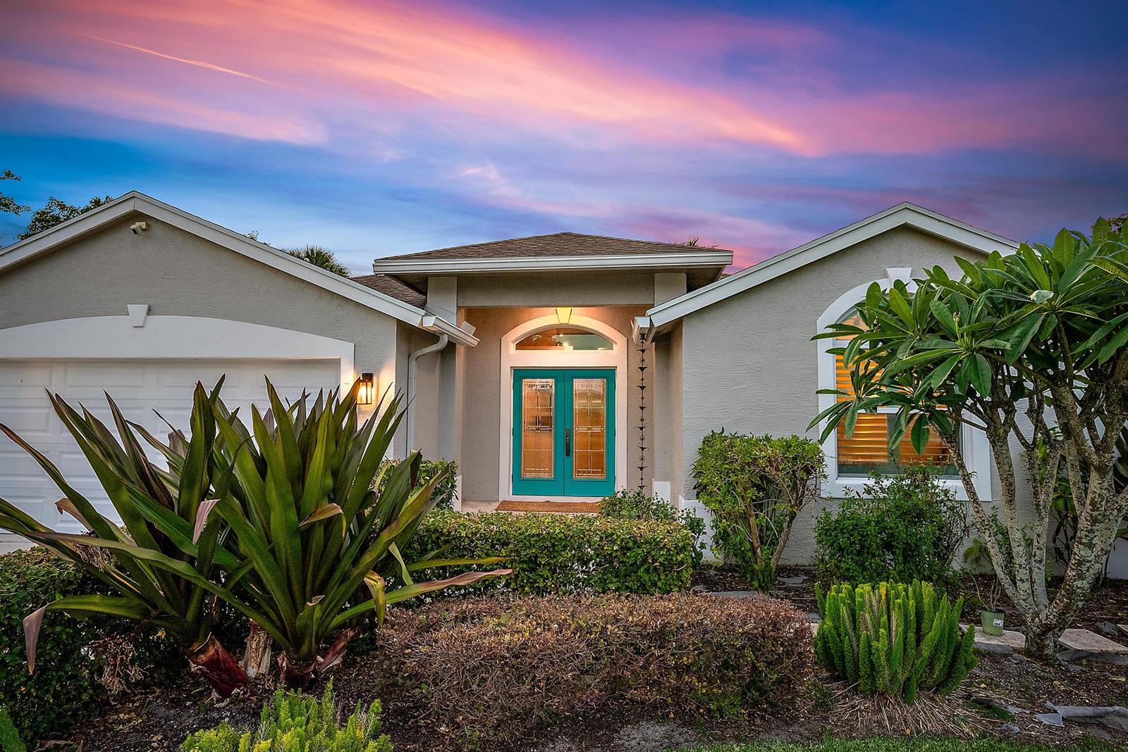 A single-story house with a teal double front door and a sunset sky above — 15129 Harriet Avenue, Jupiter FL 33458, JUPITER, FL