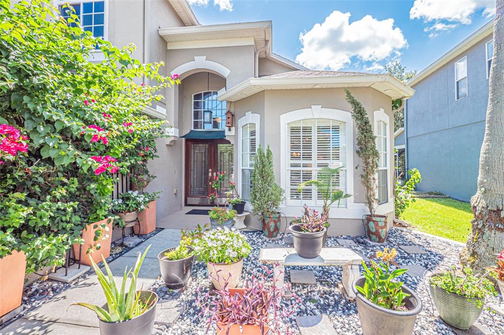 The exterior of a house features a front entrance, a bay window, and potted plants — 4315 NORTHERN DANCER WAY, ORLANDO, FL