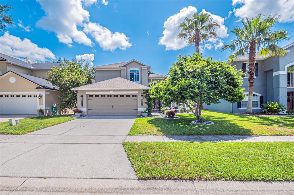 A two-story suburban house with a tan exterior, a two-car garage, and a front lawn — 4315 NORTHERN DANCER WAY, ORLANDO, FL