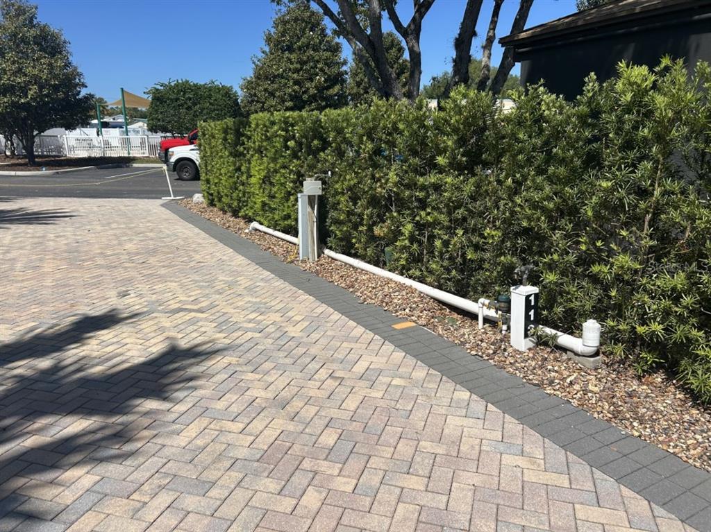 A paved driveway features a utility pedestal and a hedge bordering a residential property — 2505 PINE STREET, CLERMONT, FL