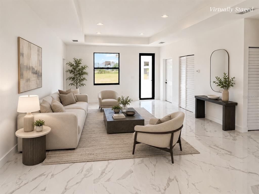 This virtually staged living room features white marble-look tile floors and a tray ceiling — 1107 NW 9TH AVENUE, CAPE CORAL, FL