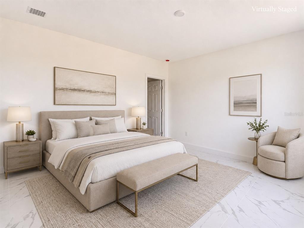 A bedroom features a king bed, a bench, an armchair, and neutral decor on tile floors — 1107 NW 9TH AVENUE, CAPE CORAL, FL
