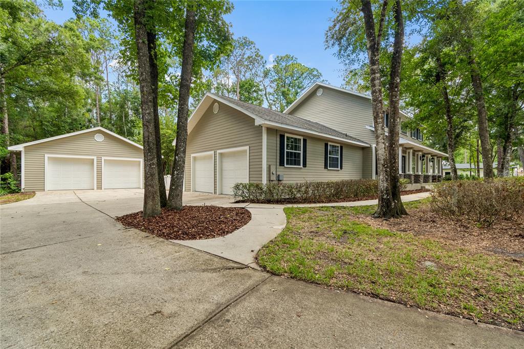 A two-story house with beige siding, a detached garage, and an attached two-car garage — 27708 SANTA ANITA BOULEVARD, WESLEY CHAPEL, FL