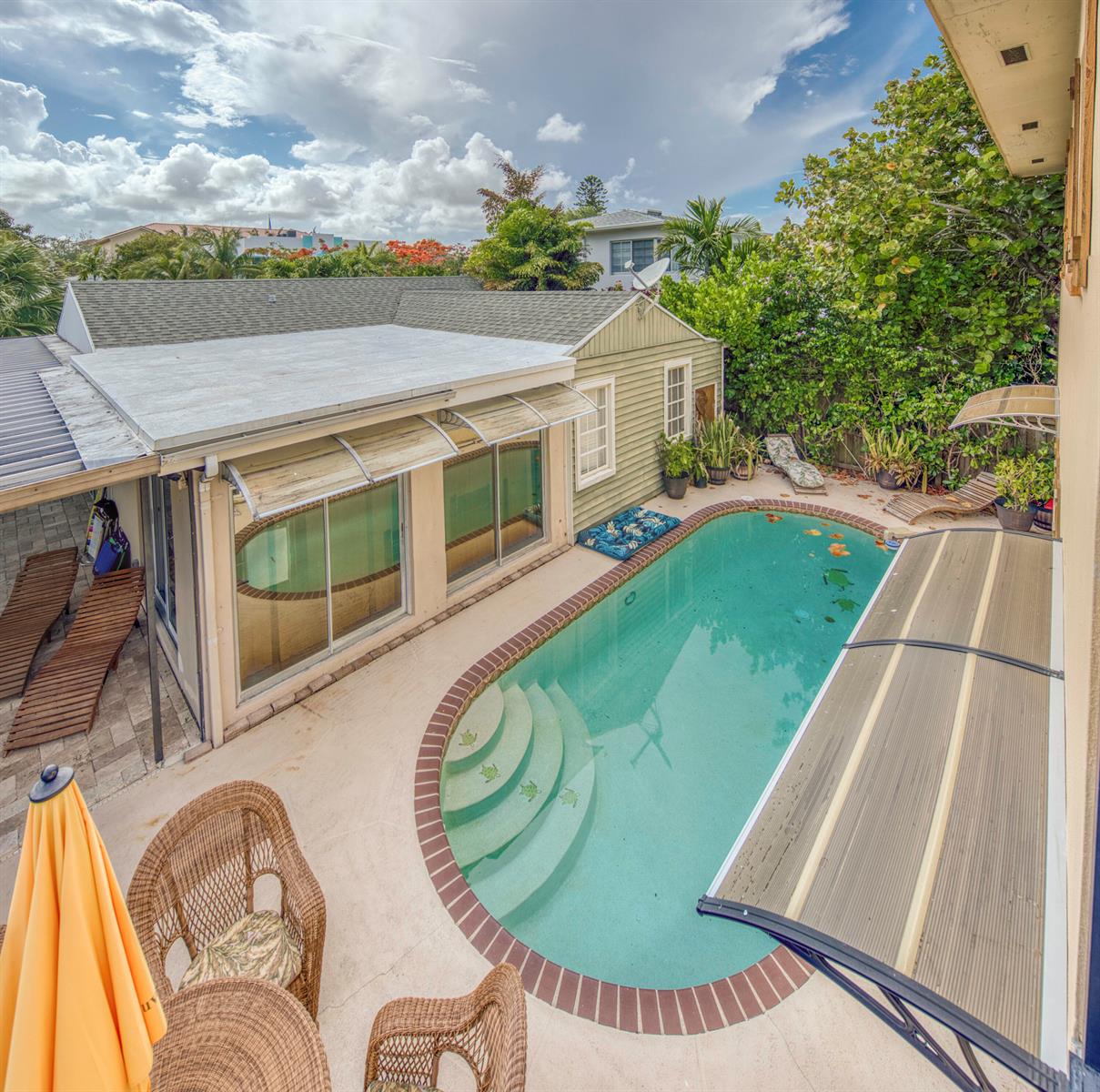 An elevated view of a backyard featuring a swimming pool, patio furniture, and a house — 216 S Ocean Breeze, Lake Worth FL 33460, LAKE WORTH, FL