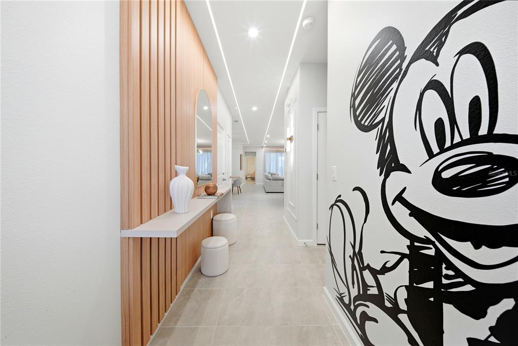 A hallway features a wood-slatted accent wall, a floating console table, and a Mickey Mouse mural — 2308 DISTANT SUN TRAIL, KISSIMMEE, FL
