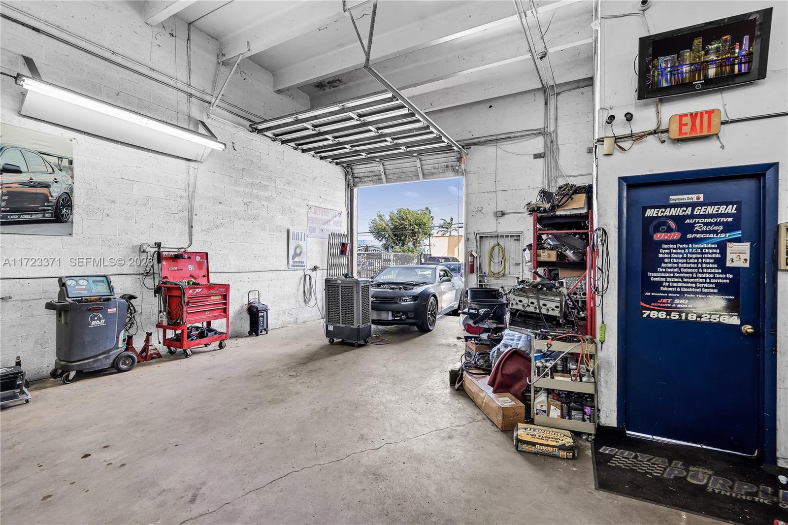 An automotive repair shop features a concrete floor, a large open bay door, and various tools — 2700 W 79th St, Hialeah FL 33016, HIALEAH, FL