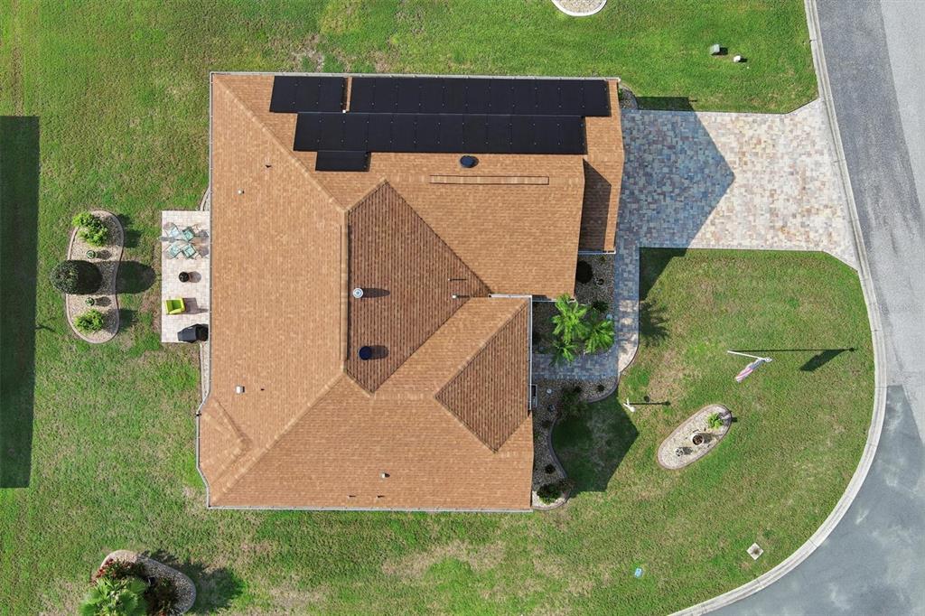 An aerial view shows a house with a shingled roof, solar panels, and a paved driveway — 17790 SE 125TH CIRCLE, SUMMERFIELD, FL