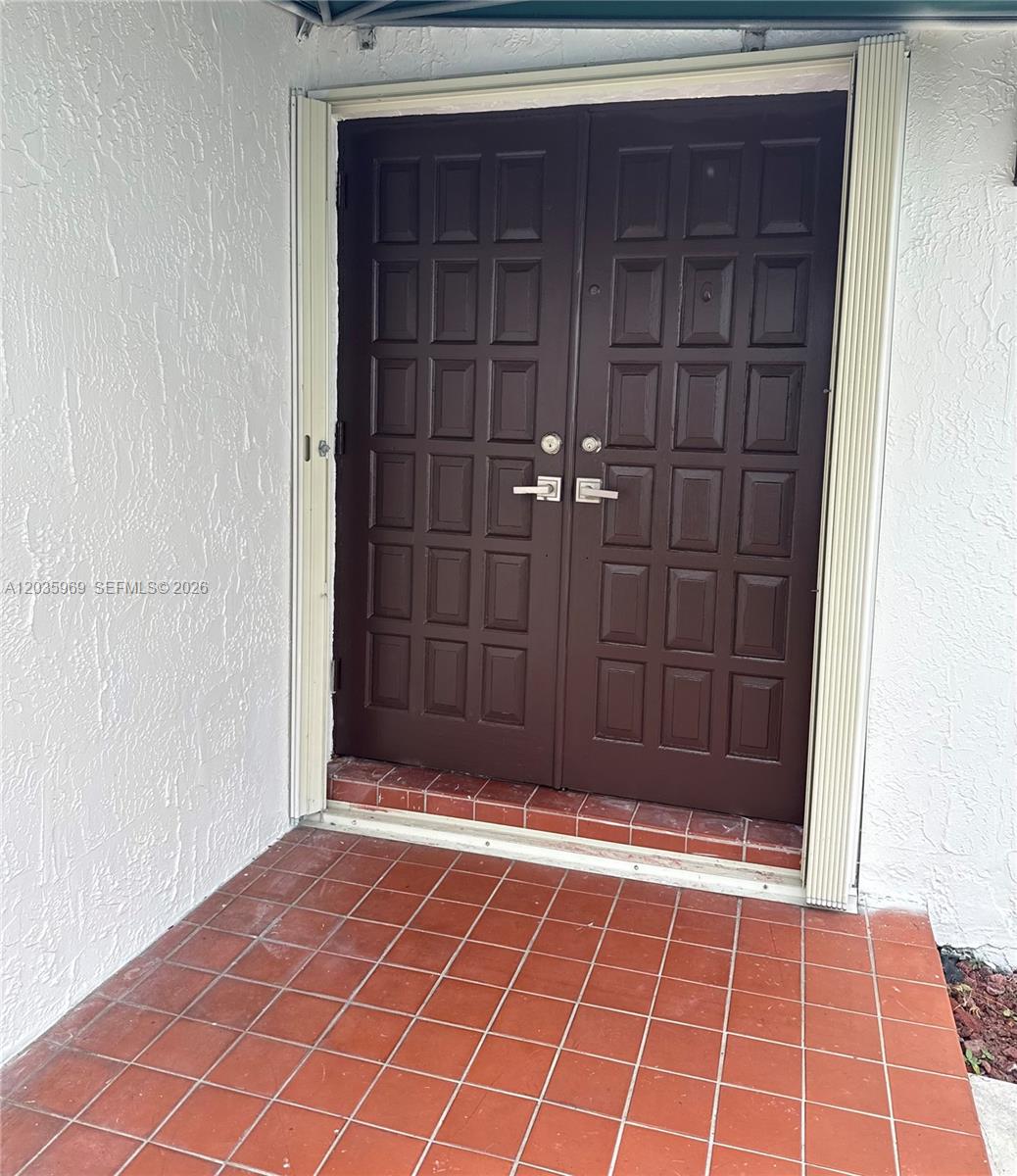 A set of dark brown double doors with paneling sits above a tiled entryway — 13326 SW 9th Ter, Miami FL 33184, MIAMI, FL
