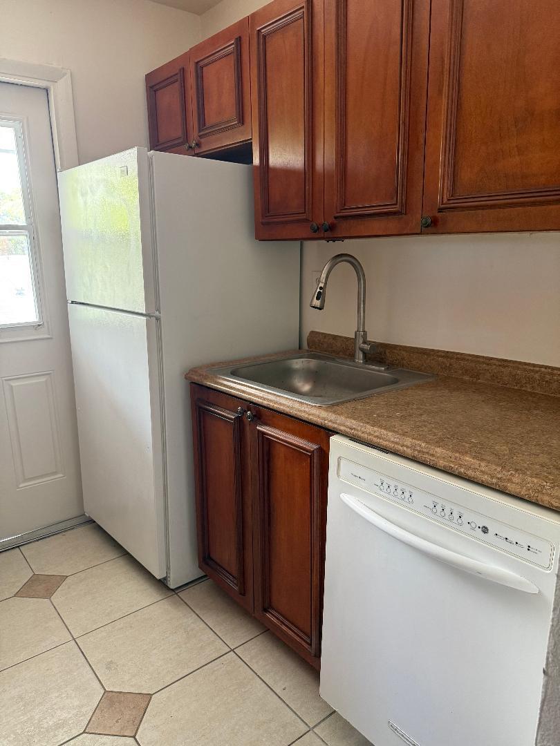 A kitchen features wood cabinets, a stainless steel sink, and white appliances — 1913 NE 2nd Street # 4, Pompano Beach FL 33060, POMPANO BEACH, FL
