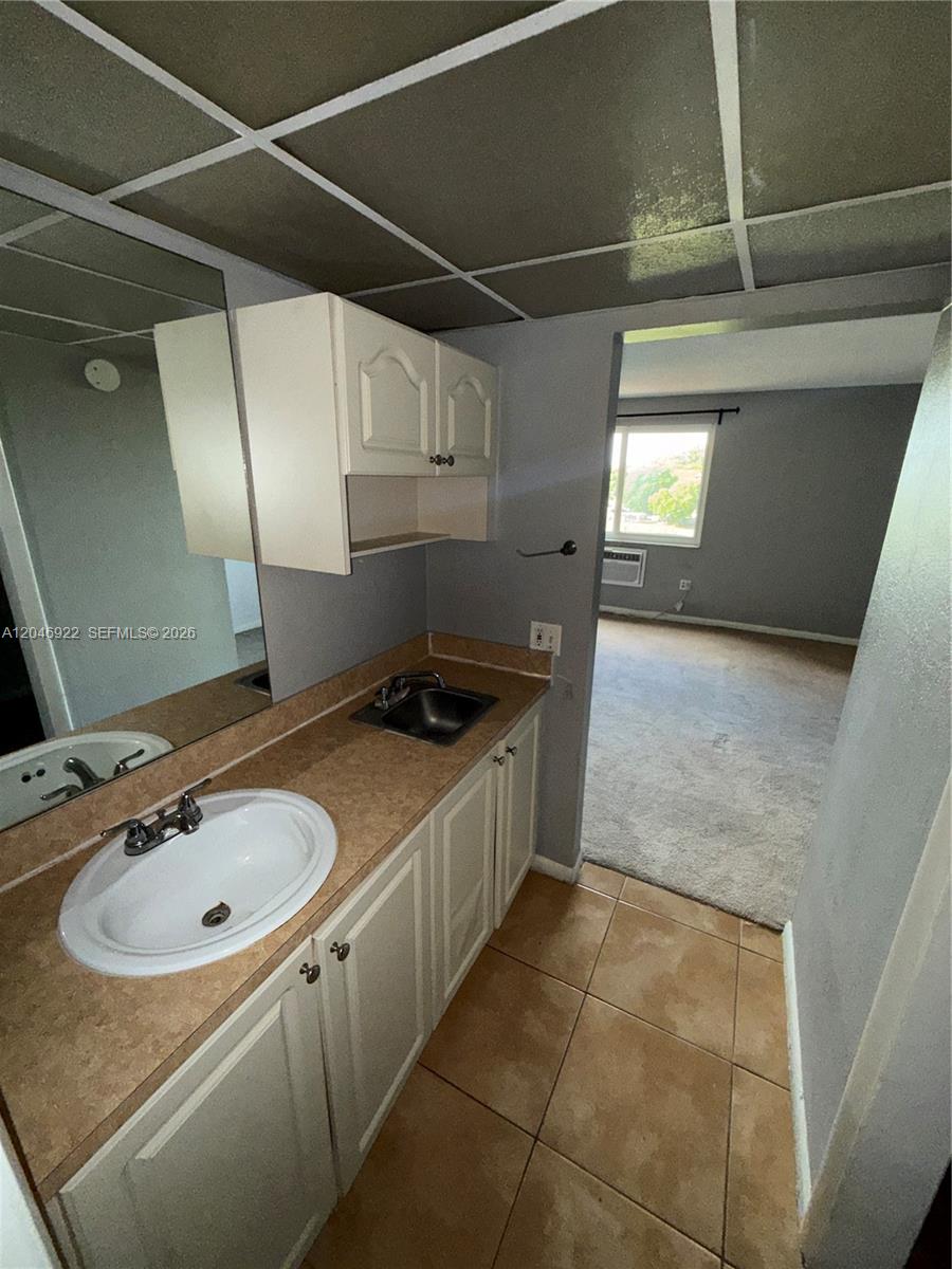 A bathroom vanity with a sink and small wet bar area leads into a bedroom — 6960 Miami Gardens Dr # 431A, Hialeah FL 33015, HIALEAH, FL