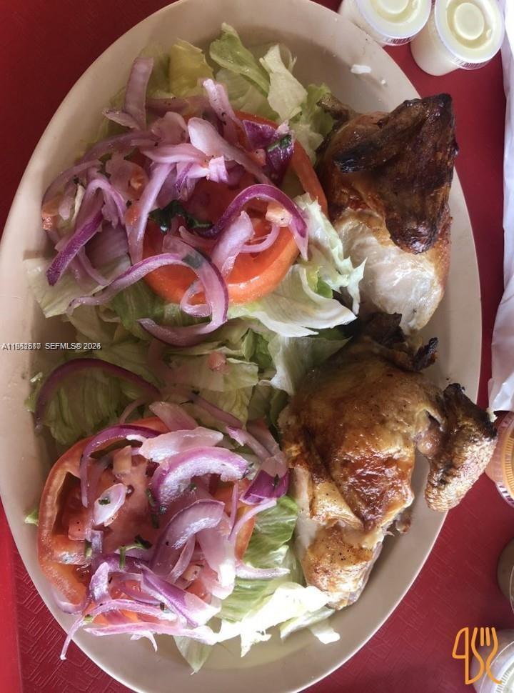 A plate of roasted chicken served with a side of lettuce, tomato, and red onion — 820 W Sample Rd, Pompano Beach FL 33064, POMPANO BEACH, FL