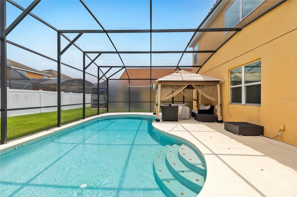 A swimming pool with a screened enclosure and a gazebo on a concrete patio — 2501 DHARMA CIRCLE, KISSIMMEE, FL