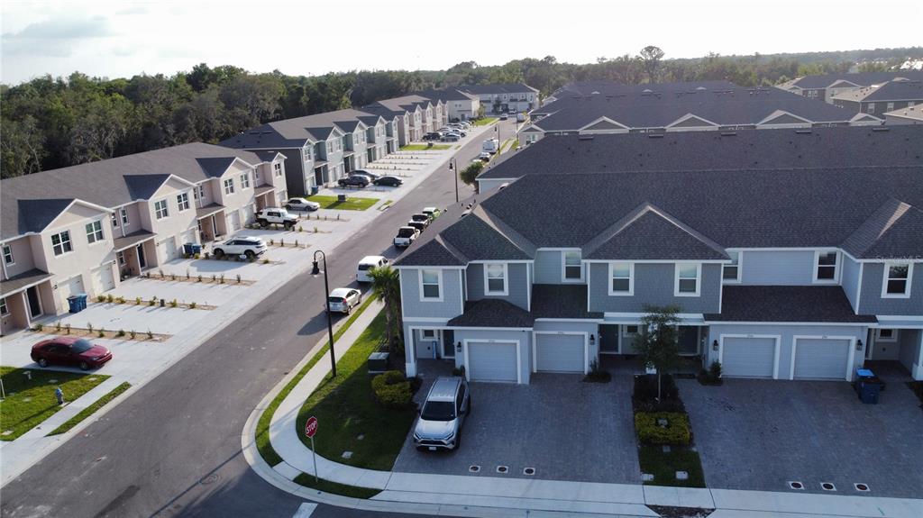 An aerial view shows multiple rows of suburban townhouses with attached garages and paved driveways — 2906 CANARY AVENUE, DAVENPORT, FL