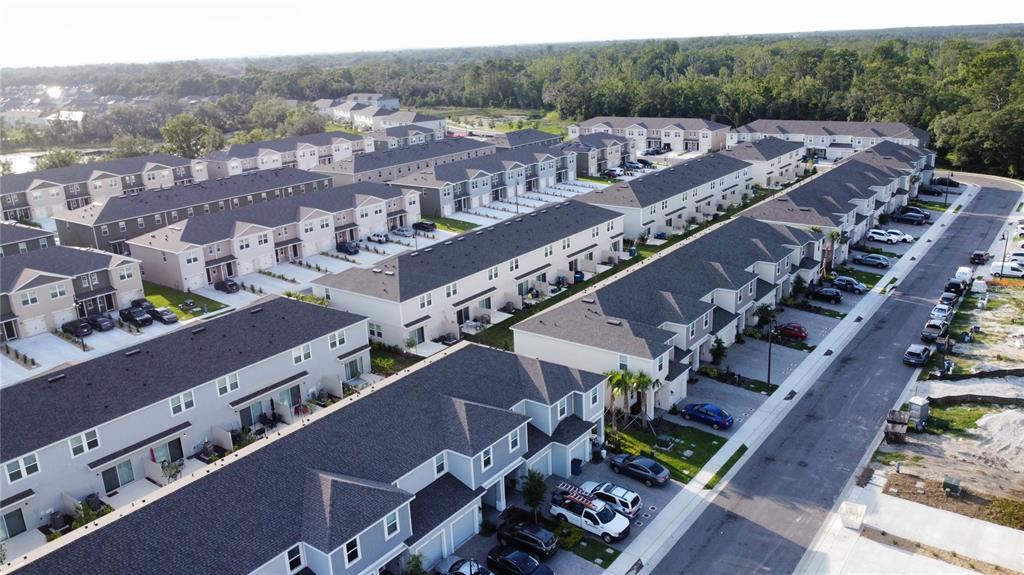 An aerial view shows multiple rows of modern townhouses with driveways and a paved street — 2906 CANARY AVENUE, DAVENPORT, FL