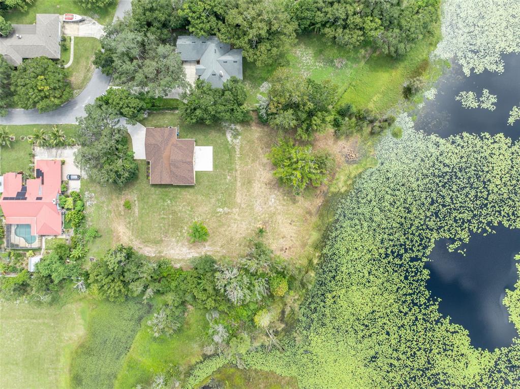 An aerial view shows a house with a brown roof situated on a grassy lot — 5762 SHERYL ANITA STREET, OVIEDO, FL