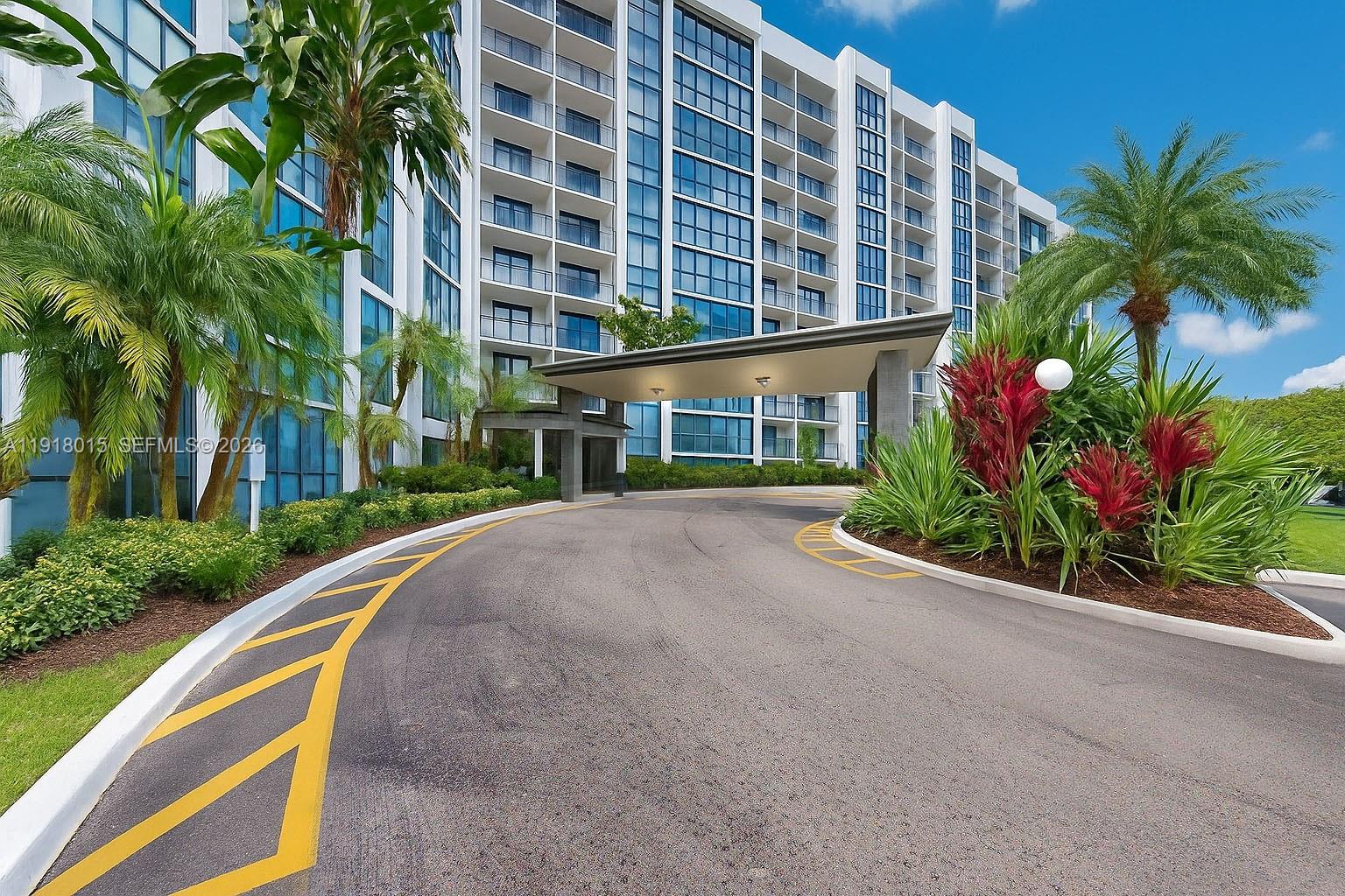 A modern high-rise building features a curved driveway leading to a covered entrance canopy — 1000 Parkview Dr # 431, Hallandale Beach FL 33009, HALLANDALE BEACH, FL