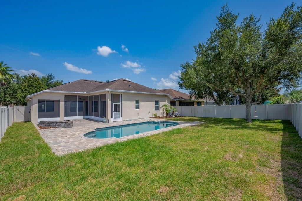 A backyard featuring a swimming pool, a paved patio, and a screened-in porch — 11109 WEMBLEY LANDING DRIVE, LITHIA, FL