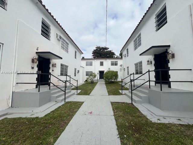 A central walkway leads between two white two-story apartment buildings with black metal railings — 535 SW 7th St # 4, Miami FL 33130, MIAMI, FL