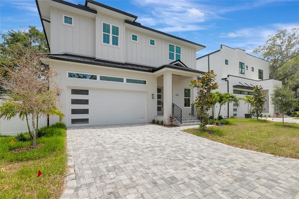 A two-story modern house with a white exterior, a paved driveway, and a garage — 3106 W COACHMAN AVENUE, TAMPA, FL