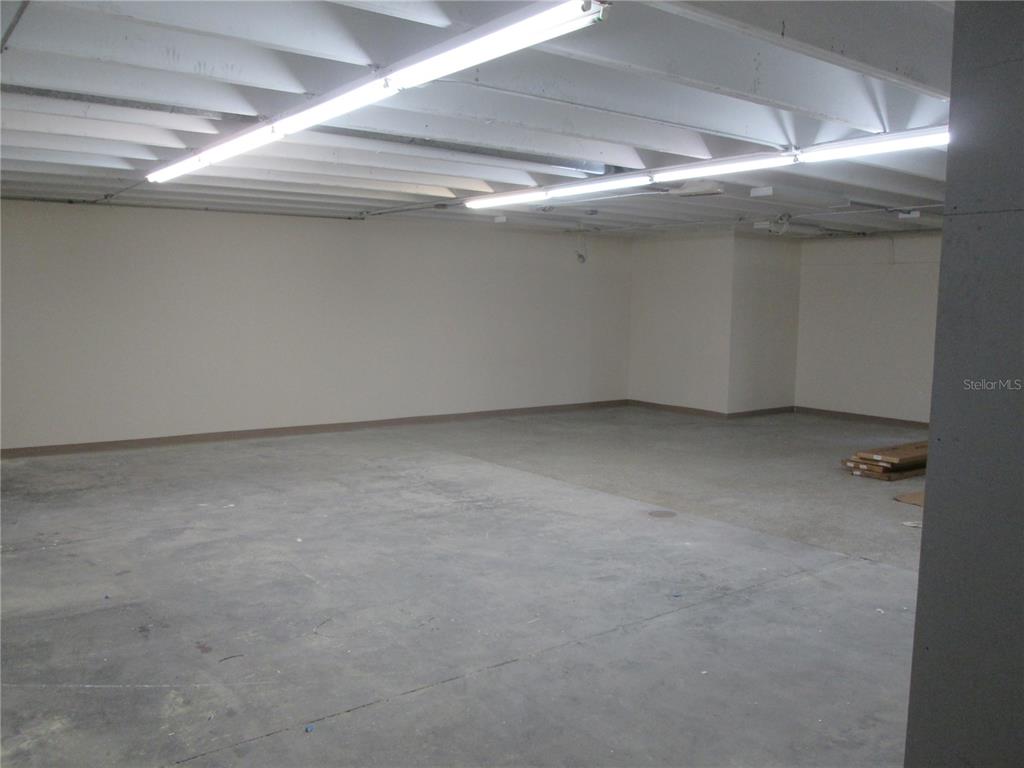 An unfinished commercial space features a concrete floor, white walls, and exposed ceiling joists — 100 W BURLEIGH BOULEVARD, TAVARES, FL