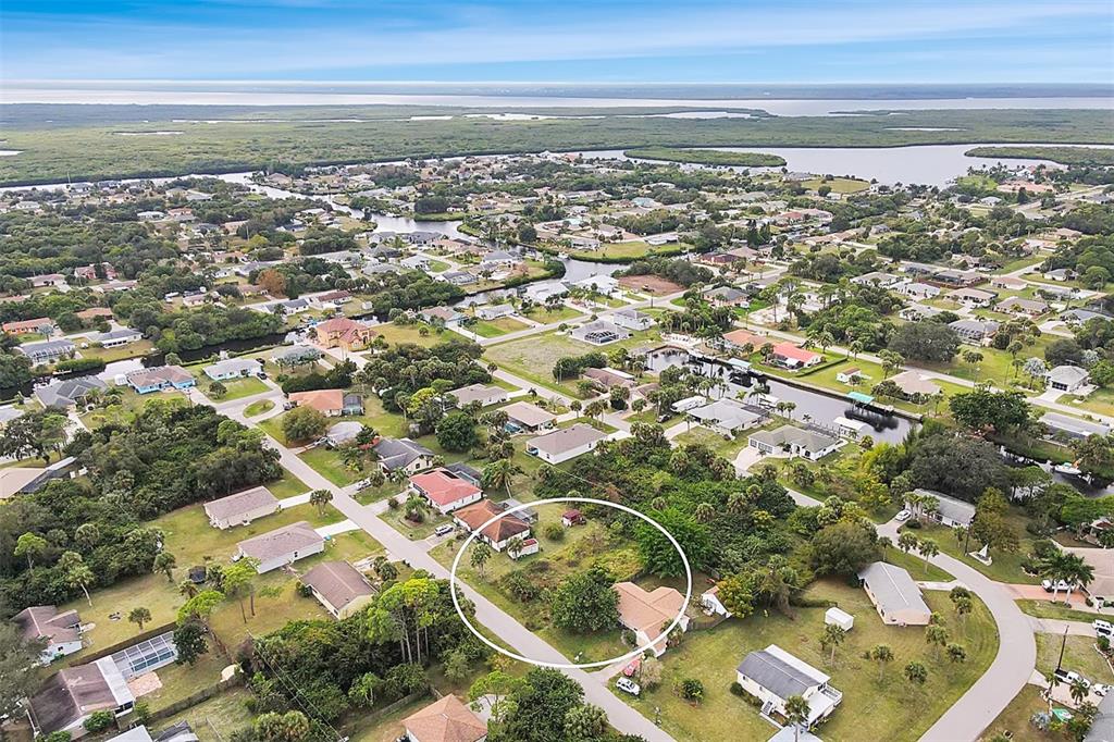 An aerial view shows a vacant, rectangular lot situated between two residential houses — 4477 HARRINGTON STREET, PORT CHARLOTTE, FL