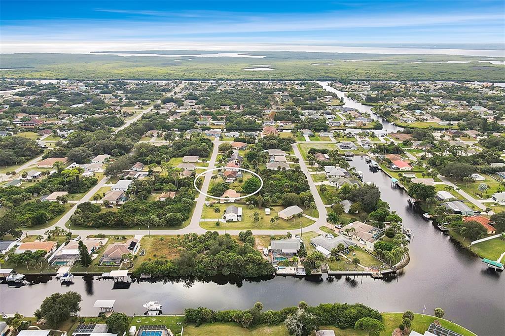 An aerial view shows a residential neighborhood with houses, canals, and a circled property — 4477 HARRINGTON STREET, PORT CHARLOTTE, FL
