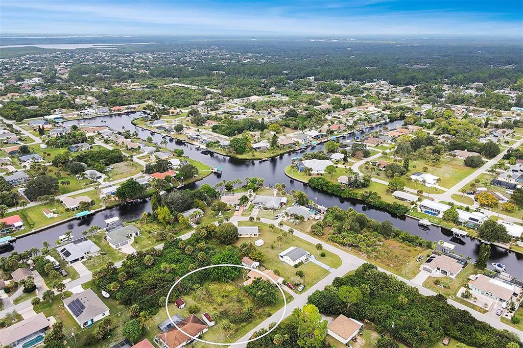 An aerial view shows a residential neighborhood with a vacant lot circled in white — 4477 HARRINGTON STREET, PORT CHARLOTTE, FL