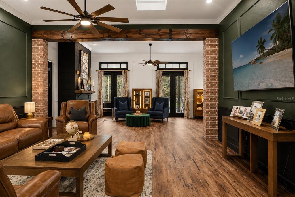A covered porch features a dark wood floor, black support columns, and a hanging bench — 17163 BENES ROUSH ROAD, BROOKSVILLE, FL