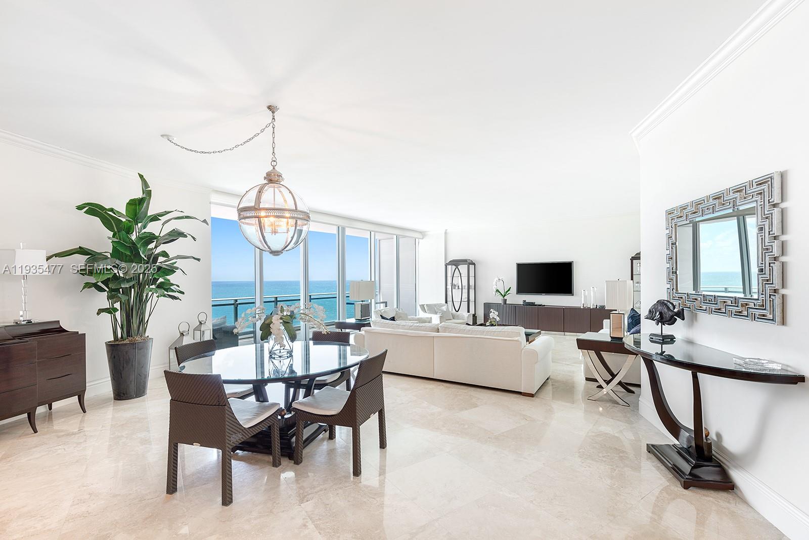 A bright, open-concept living and dining area features marble floors, floor-to-ceiling windows, and ocean views — 10295 Collins Ave # 803, Bal Harbour FL 33154, BAL HARBOUR, FL