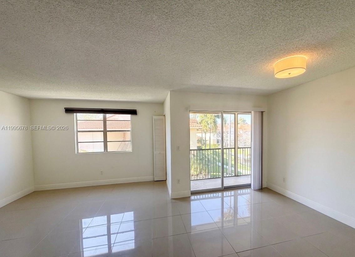 This room features tile flooring, built-in wall shelves, a ceiling light, and a sliding glass door — 1253 SW 46th Ave # 1608, Pompano Beach FL 33069, POMPANO BEACH, FL