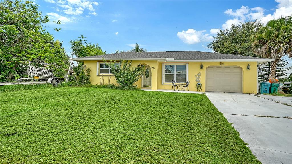 A yellow single-story house features a front lawn, a driveway, and an attached garage — 481 W TARPON BOULEVARD NW, PORT CHARLOTTE, FL