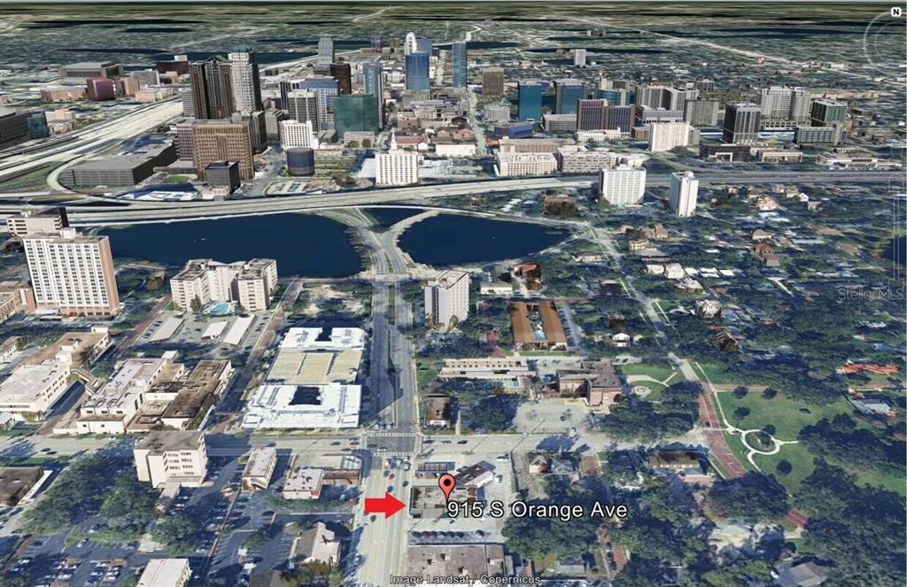 This aerial view shows a commercial building in an urban setting with surrounding city infrastructure — 915 S ORANGE AVENUE, ORLANDO, FL